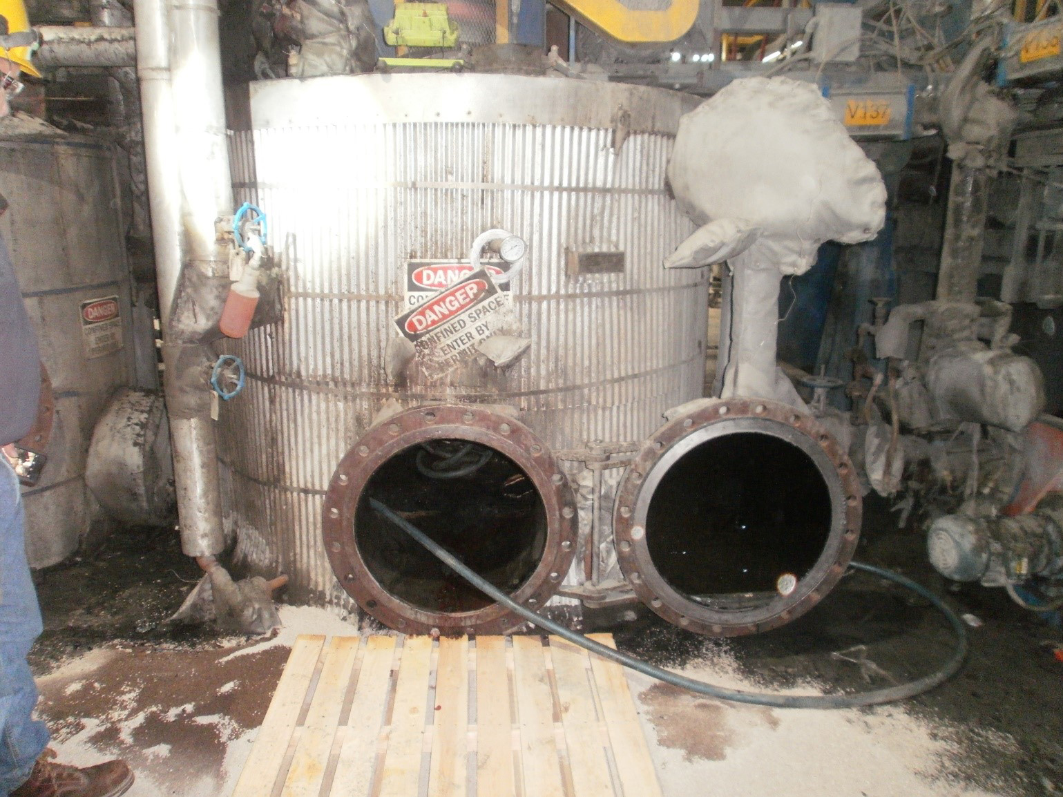 A view of the tank from the outside showing the small entry and exit opening. The power source of this tank was not properly locked out and a worker was killed while inside this confined space when it suddenly turned on.